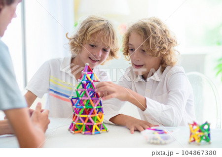 Child playing with magnetic building blocks. Child playing with magnetic building blocks. 104867380