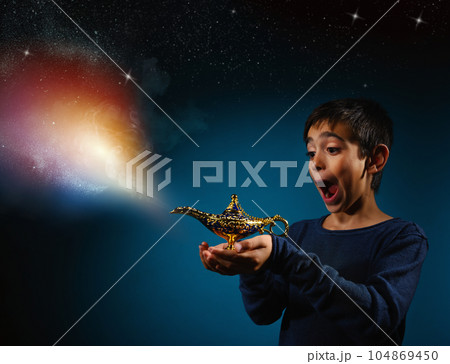 Amazed child with magic Aladin lamp in hand Amazed child with magic Aladin lamp in hand 104869450