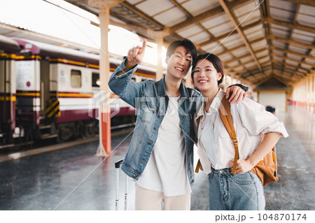 Asian couple at railway station have happy moment. Tourism and travel in the summer Asian couple at railway station have happy moment. Tourism and travel in the summer 104870174