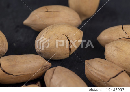 cracked unpeeled pecans close-up on the table cracked unpeeled pecans close-up on the table 104870374