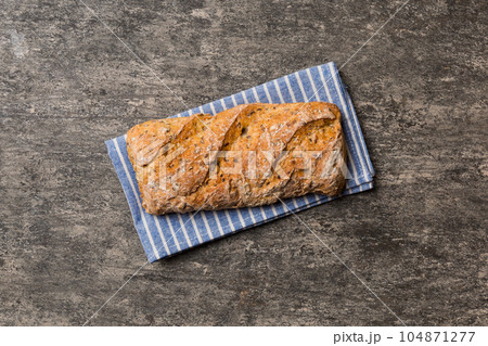 Fresh loaves of bread with wheat and gluten on a colored table. bread on napkin on rustic background, fresh bread top view 104871277