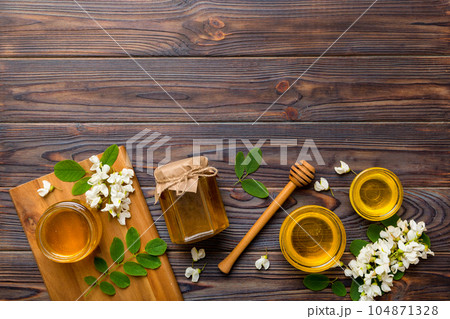 honey jar with acacia flowers and leaves. fresh honey top view flat lay honey jar with acacia flowers and leaves. fresh honey top view flat lay 104871328