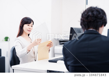 オフィスで事務作業をする女性社員 オフィスで事務作業をする女性社員 104871843