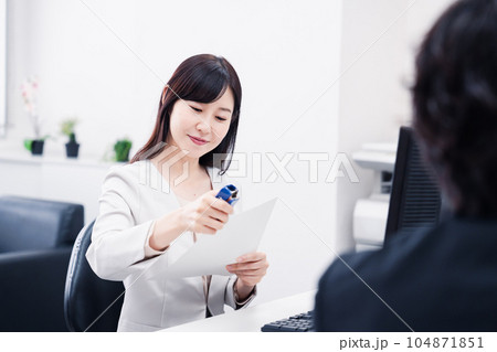 オフィスで事務作業をする女性社員 オフィスで事務作業をする女性社員 104871851