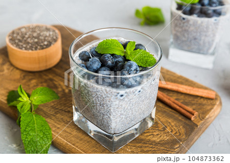 Healthy breakfast or morning with chia seeds vanilla pudding and blueberry berries on table background, vegetarian food, diet and health concept. Chia pudding with coconut milk and blueberry Healthy breakfast or morning with chia seeds vanilla pudding and blueberry berries on table background, vegetarian food, diet and health concept. Chia pudding with coconut milk and blueberry 104873362