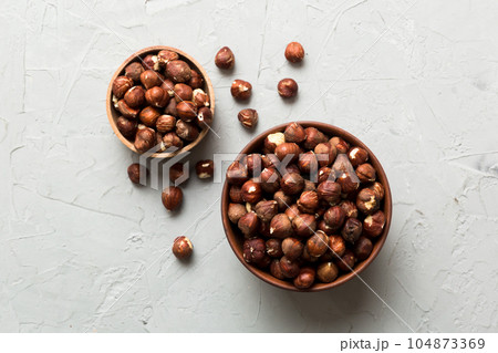 Wooden bowl full of hazelnuts on table background. Healthy eating concept. Super foods Wooden bowl full of hazelnuts on table background. Healthy eating concept. Super foods 104873369