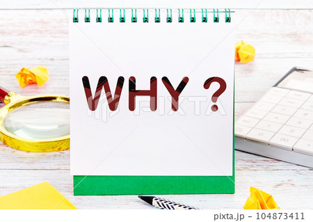 Why Text on a sheet of notepad standing on the table next to a magnifying glass, calculator, stickers Why Text on a sheet of notepad standing on the table next to a magnifying glass, calculator, stickers 104873411