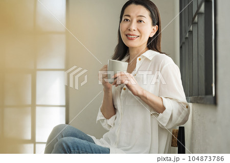 自宅でコーヒーを飲むミドル女性 104873786