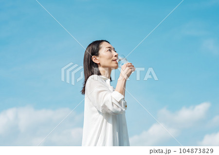 コップで水を飲むミドル世代の女性 コップで水を飲むミドル世代の女性 104873829