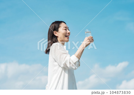 コップで水を飲むミドル世代の女性 コップで水を飲むミドル世代の女性 104873830