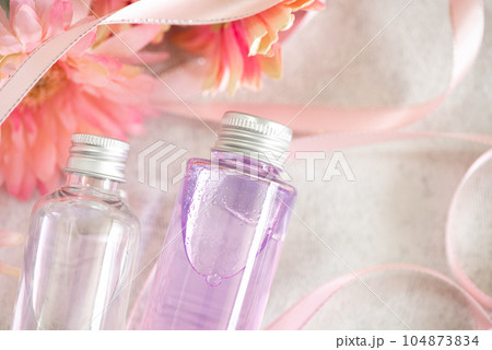化粧品の入ったプラスチックボトル2個とリボンとガーベラ 化粧品の入ったプラスチックボトル2個とリボンとガーベラ 104873834