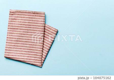 top view with red empty kitchen napkin isolated on table background. Folded cloth for mockup with copy space, Flat lay. Minimal style top view with red empty kitchen napkin isolated on table background. Folded cloth for mockup with copy space, Flat lay. Minimal style 104875162