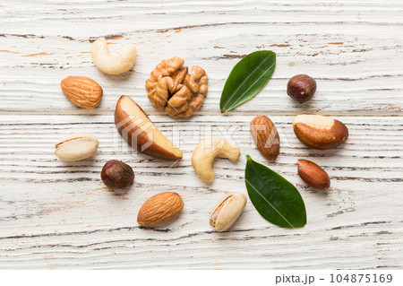 Composition of nuts , flat lay - mix hazelnuts, cashews, almonds on table background. healthy eating concepts and food background Composition of nuts , flat lay - mix hazelnuts, cashews, almonds on table background. healthy eating concepts and food background 104875169