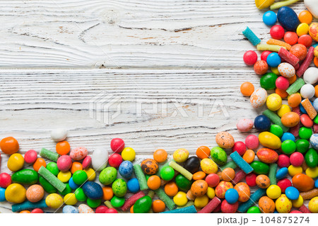 Mixed collection of colorful candy, on colored background. Flat lay, top view. frame of colorful chocolate coated candy 104875274