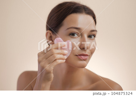 Woman Youth and Skincare Photo with Self Face Massage Gua Sha Tool 104875324