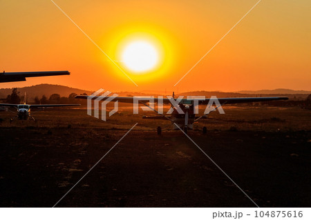 Small propeller airplanes at sunset in Arusha airport, Tanzania Small propeller airplanes at sunset in Arusha airport, Tanzania 104875616