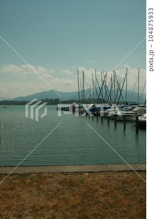 Long row of sailboats by the jetty at the Chiemsee in Breitbrunn am Chiemsee in Bavaria, Germany 104875933