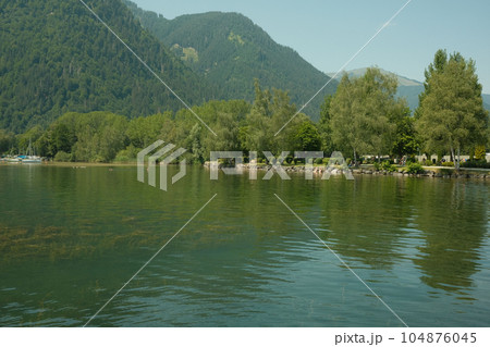 Beautiful view of a the Zeller lake at Zell am See with reflection of trees in the water, Austria Beautiful view of a the Zeller lake at Zell am See with reflection of trees in the water, Austria 104876045