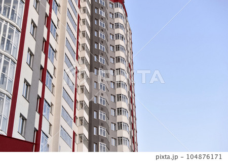 Beautiful high-rise panel residential building against the blue sky. A high-rise building in the city. A new house. 104876171