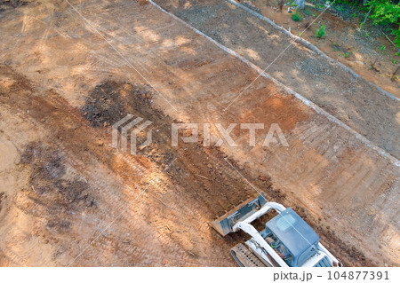 Tractors equipped with tools to preparing terrain for landscaping project 104877391