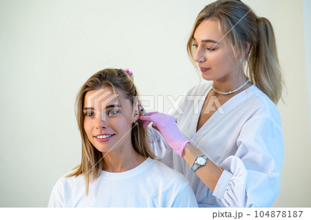 Doctor in protective medical gloves doing hair injection head rejuvenation hair loss treatment. 104878187