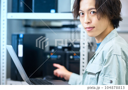 サーバを整備中のパソコンに向かうエンジニア サーバを整備中のパソコンに向かうエンジニア 104878813