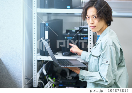 サーバを整備中のパソコンに向かうエンジニア 104878815