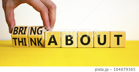 Think or bring about symbol. Businessman turns wooden cubes and changes words think about to bring about. Beautiful yellow table, white background, copy space. Business, think or bring about concept. 104879365