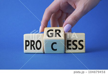 Process and Progress symbol. Businessman hand turns wooden cubes and changes the word Process and Progress. Beautiful blue background. Business and Process and Progress concept. Copy space Process and Progress symbol. Businessman hand turns wooden cubes and changes the word Process and Progress. Beautiful blue background. Business and Process and Progress concept. Copy space 104879458