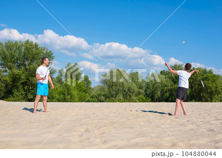 Happy family have fun on summer vacation. Sports games on the beach. 104880044