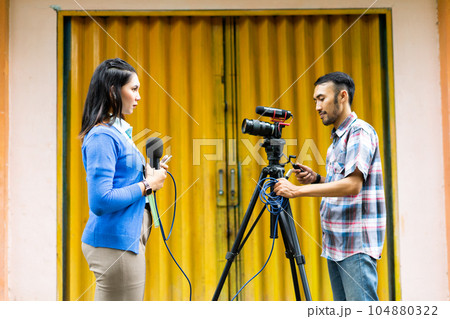 a female reporter and a cameraman prepare for news recording 104880322