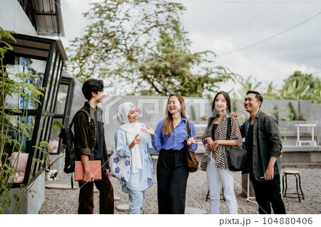 Asian university students stand up while chatting in an outdoor 104880406