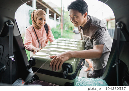muslim couple packing suitcase in the car 104880537