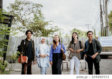 smiling group of Asian students standing in an outdoor coworking space 104880553
