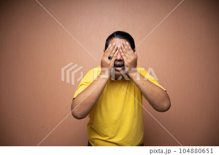 old asian man covering his face feeling afraid or fear old asian man covering his face feeling afraid or fear 104880651