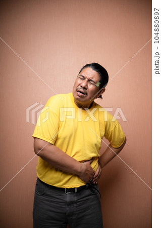 old asian man suffering from stomachache clenching stomach old asian man suffering from stomachache clenching stomach 104880897