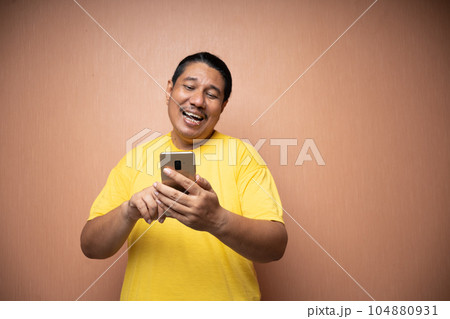 old asian man holding handphone and using it to communicate 104880931