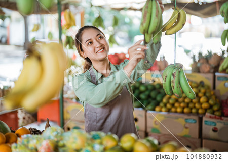 beautiful female employee checking the bananas beautiful female employee checking the bananas 104880932
