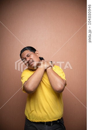 old asian man suffering from shoulder pain with clenching his shoulder 104880946