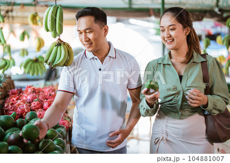 couple of asian customer choosing the avocados 104881007