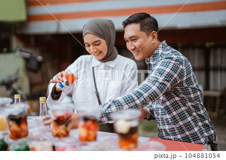 girl in a veil and a man sells mix fruit beverage and juice 104881054