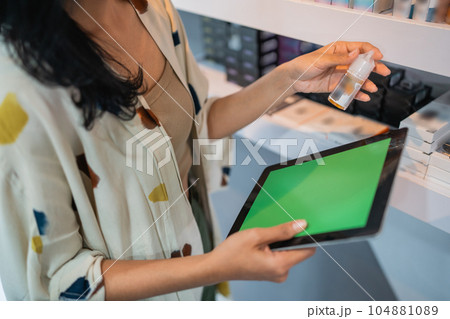 female shopkeeper holding the digital tablet with green screen 104881089