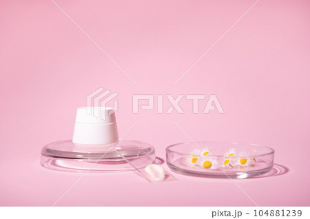 White stylish mockup jar and chamomile flowers in Petri dish and lab glass with a swatch of moisturizer, pink background White stylish mockup jar and chamomile flowers in Petri dish and lab glass with a swatch of moisturizer, pink background 104881239