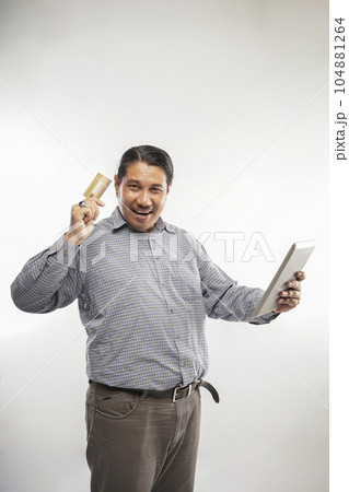 old asian man standing holding credit card and tablet white background 104881264