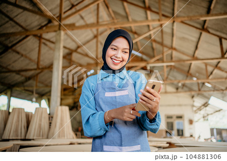 Muslim businesswoman uses a cell phone to send a message 104881306