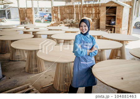 businesswoman in veil smiles with crossed hands in wood craft store 104881463