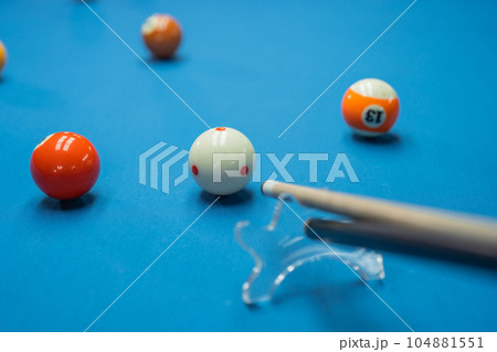 the cue stick poking the white ball helped by the bridge 104881551