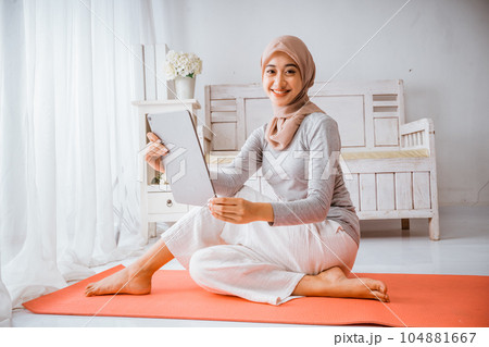 muslim hijab woman watching home work out tutorial from tablet 104881667