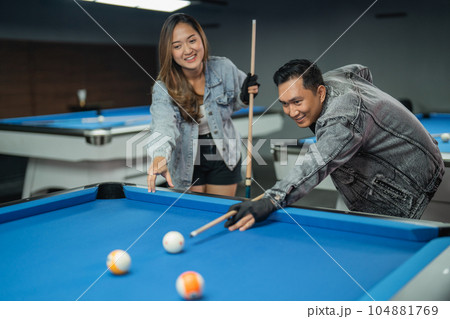 female pool player pointing on the object ball 104881769