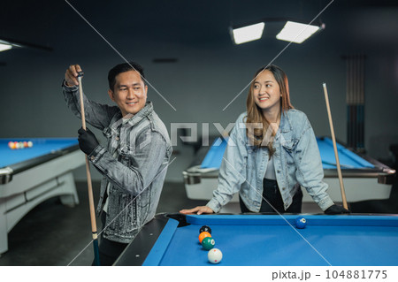 female player looking at the male player that gives the chalk at his stick female player looking at the male player that gives the chalk at his stick 104881775
